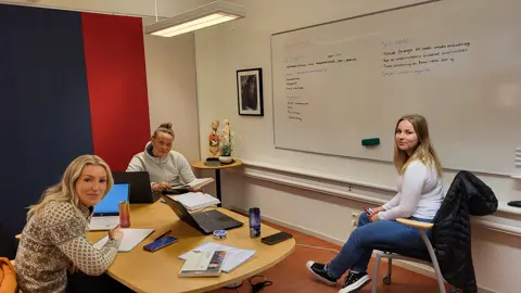 Tre unga kvinnor studerar tillsammans i ett grupprum på lärcentrum.